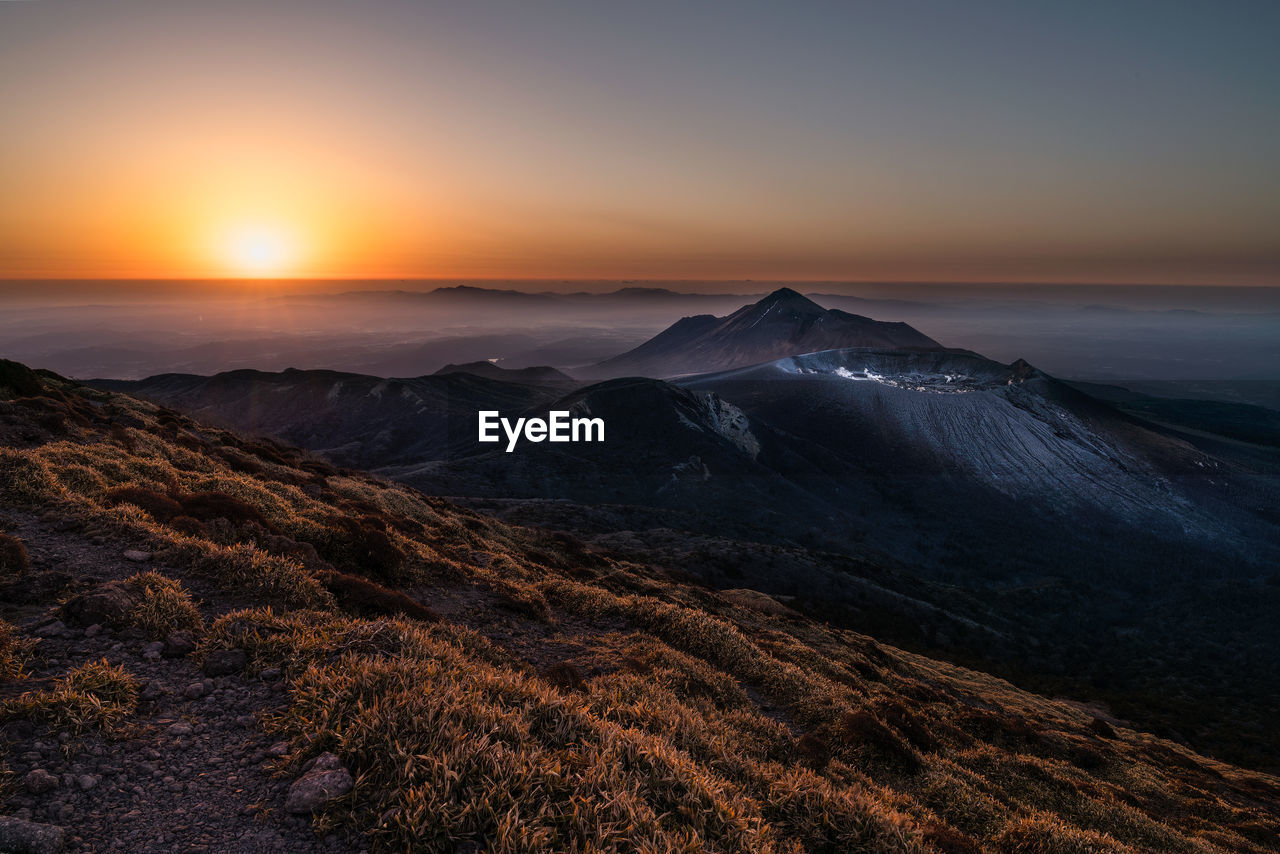 Scenic view of mountain range against clear sky during sunrise