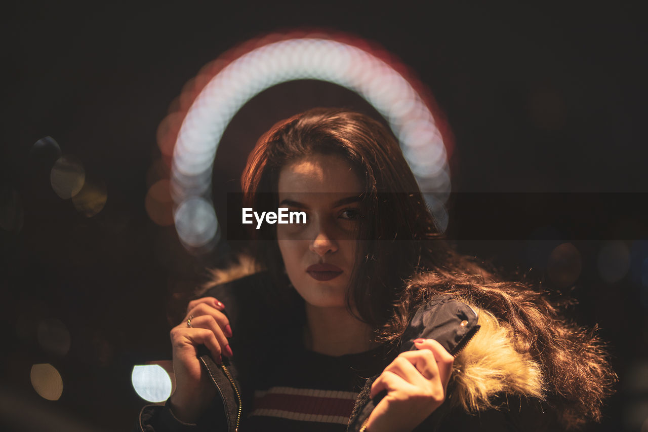 Portrait of beautiful young woman wearing warm clothing at night