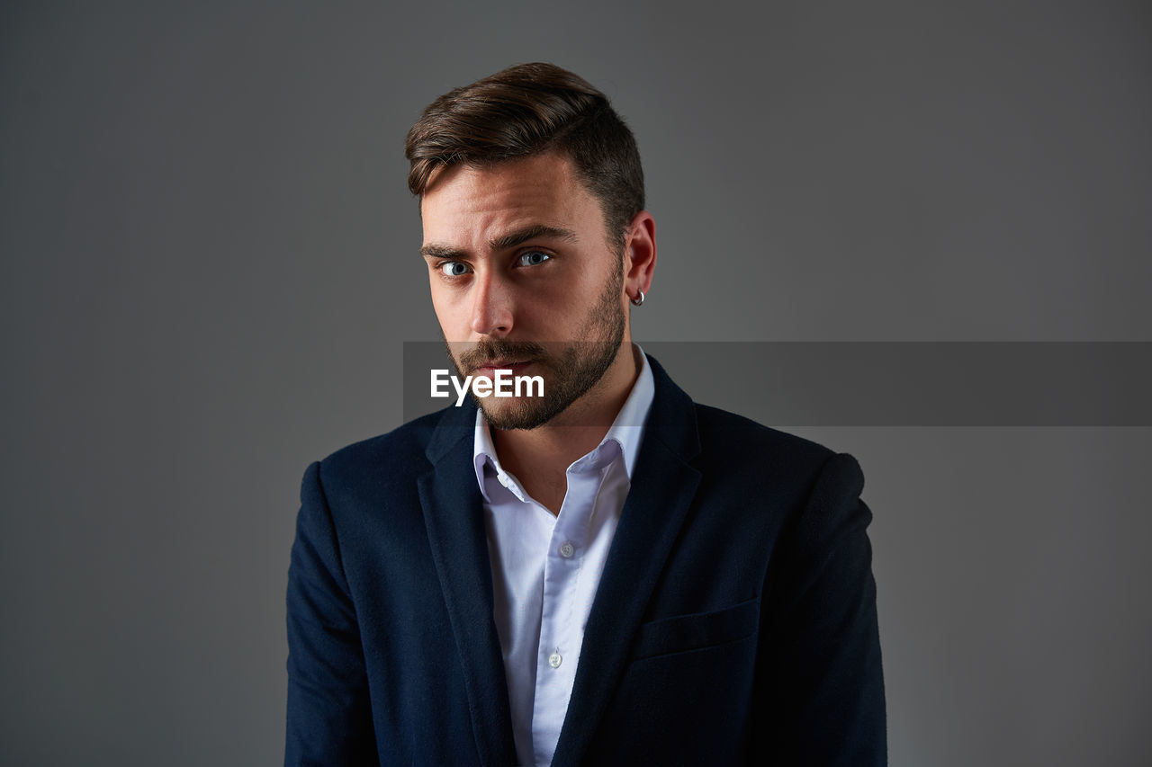 PORTRAIT OF YOUNG MAN AGAINST WHITE BACKGROUND