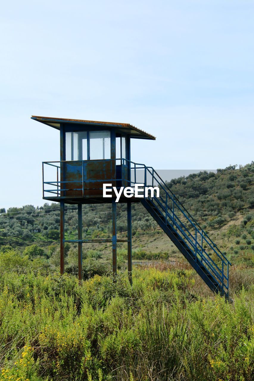 architecture, built structure, sky, nature, plant, land, grass, no people, day, landscape, tranquility, outdoors, scenics - nature, environment, observation point, green, non-urban scene, tranquil scene, field, hut, building exterior, tower, man made structure, rural area, wood, security, beauty in nature, mountain