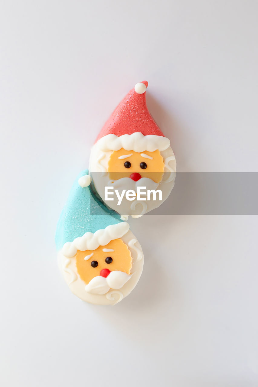 Two sweet dessert in the form of a santa claus head, with a red and blue cap