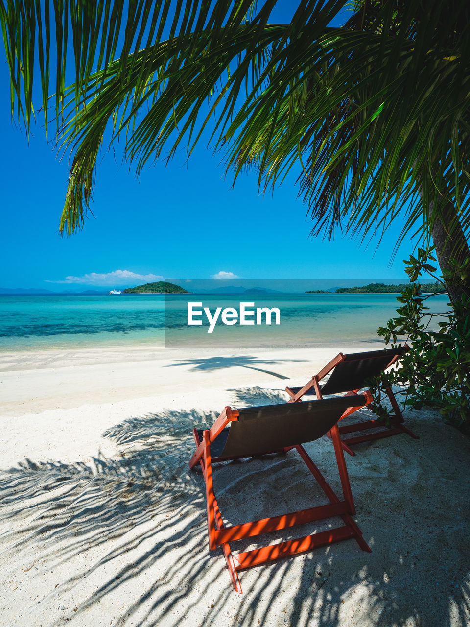 Koh mak island turquoise water, relax chair on white sand beach with coconut palm tree. thailand.