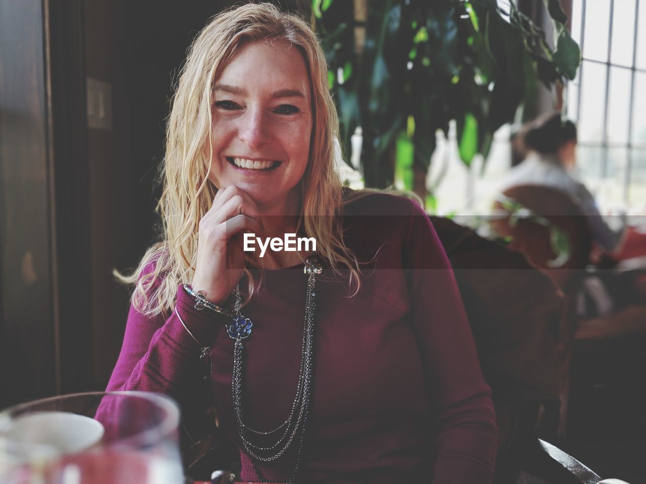 Portrait of smiling young woman sitting at restaurant