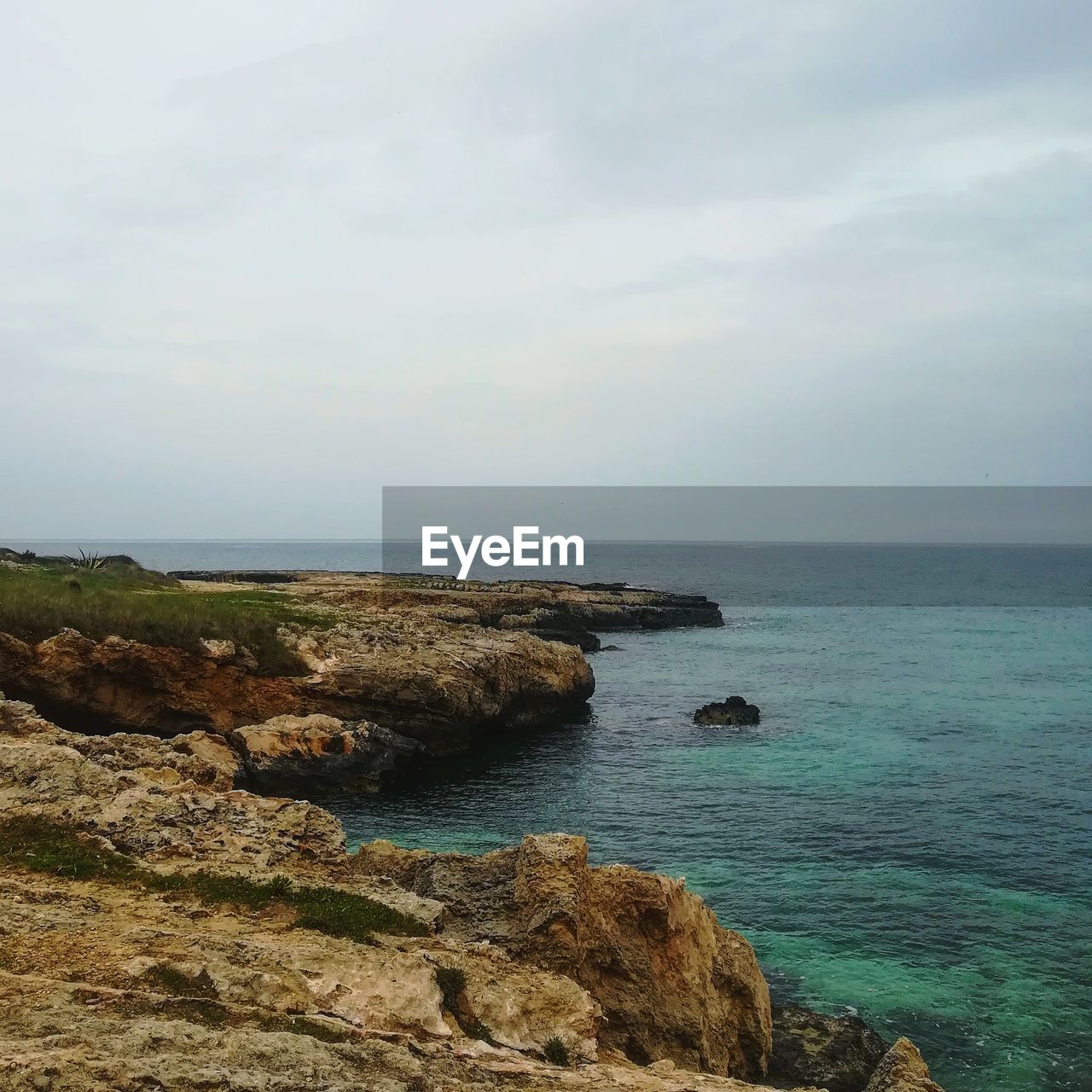 SCENIC VIEW OF ROCK FORMATION IN SEA AGAINST SKY