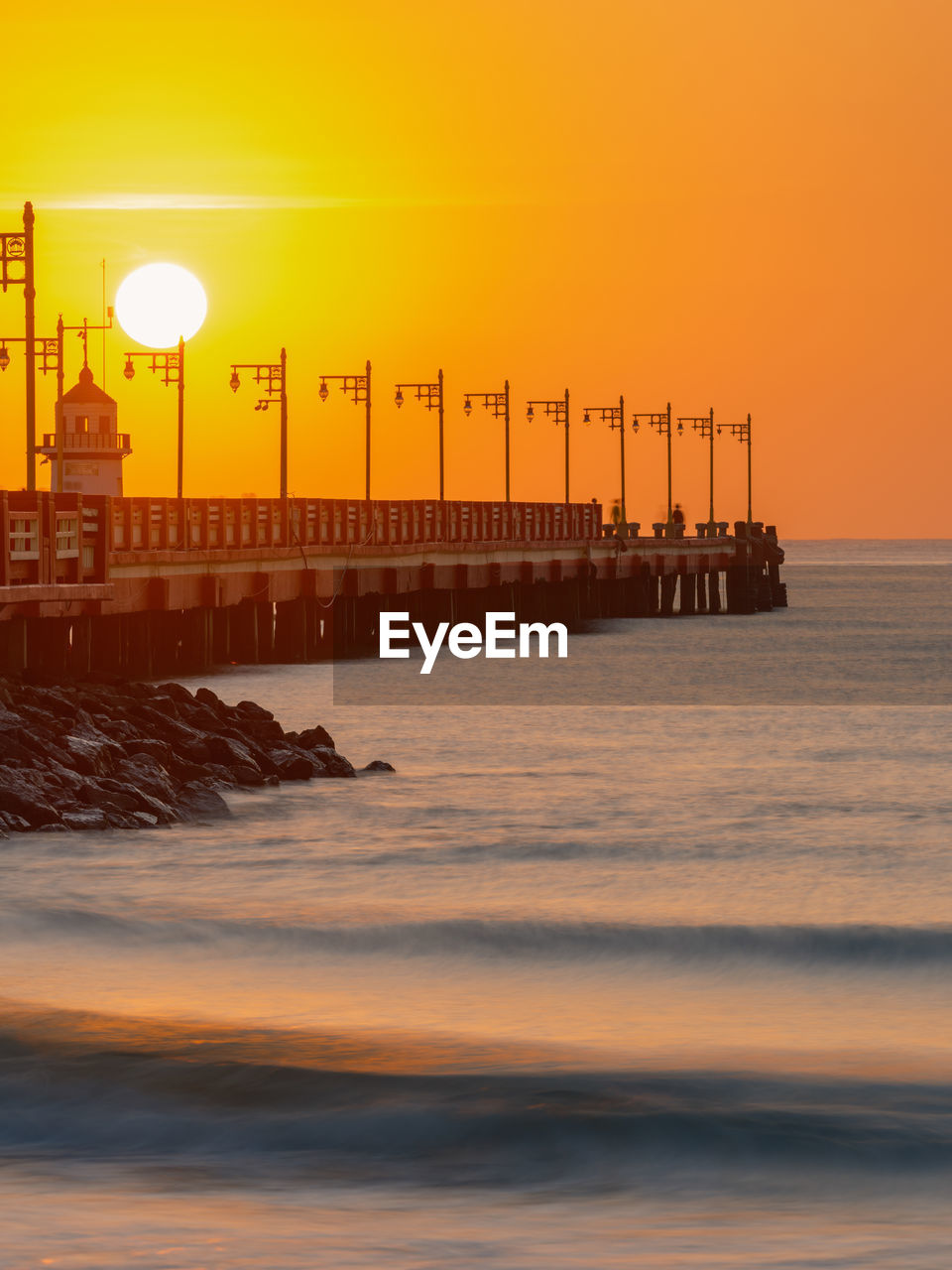 Beautiful sea and the bridge stretches out into the middle of the water with rows of lampposts