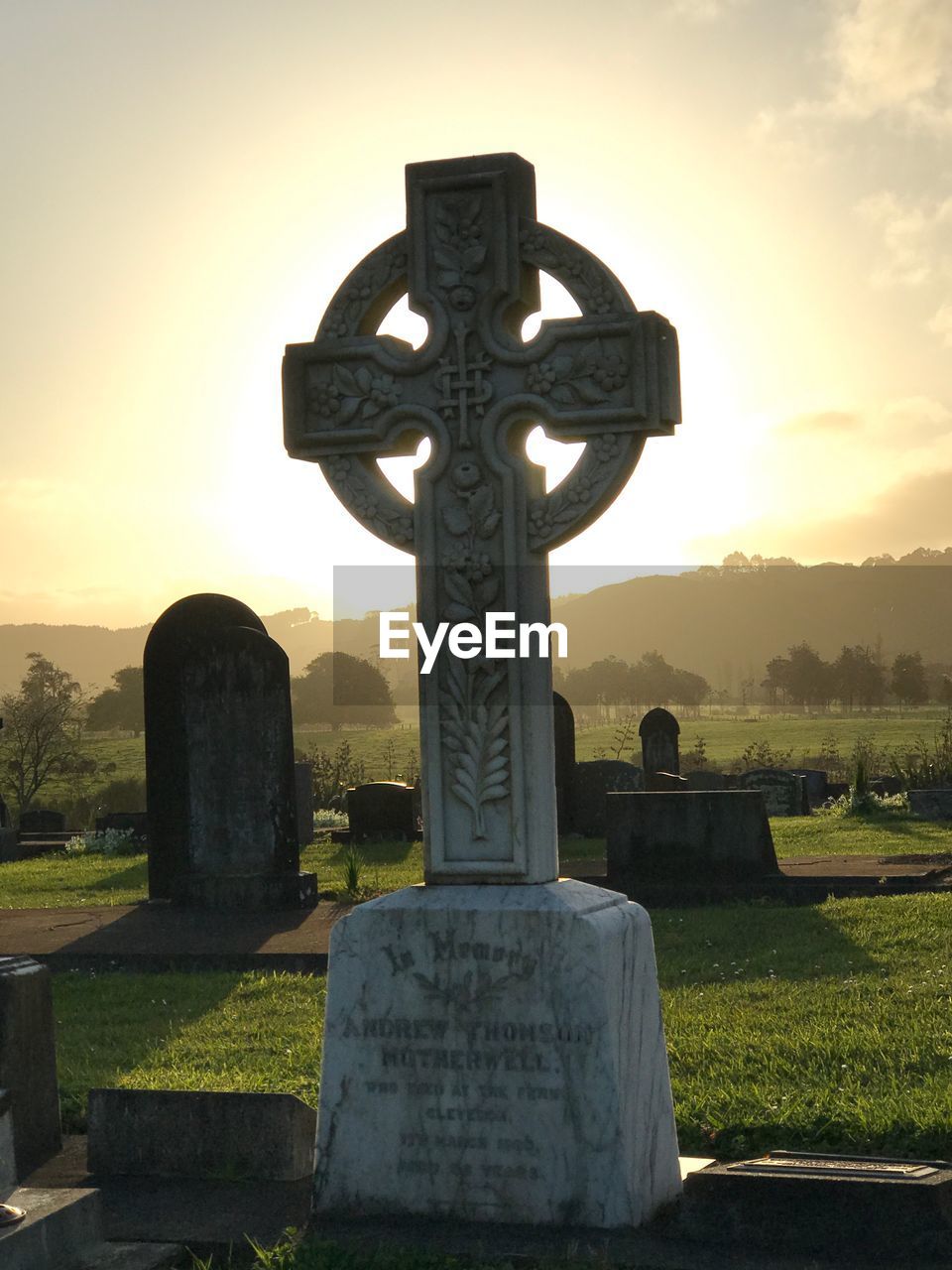 VIEW OF CROSS IN CEMETERY AGAINST SKY