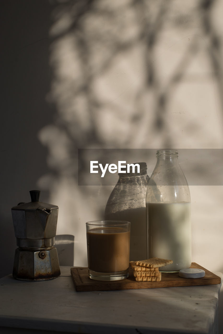 COFFEE CUP ON TABLE AGAINST GLASS