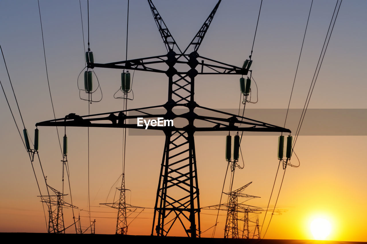 low angle view of silhouette electricity pylon against sky during sunset