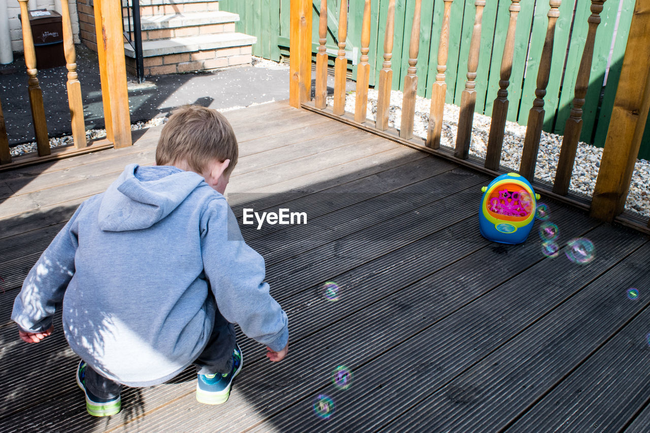 High angle view of boy playing with bubbles