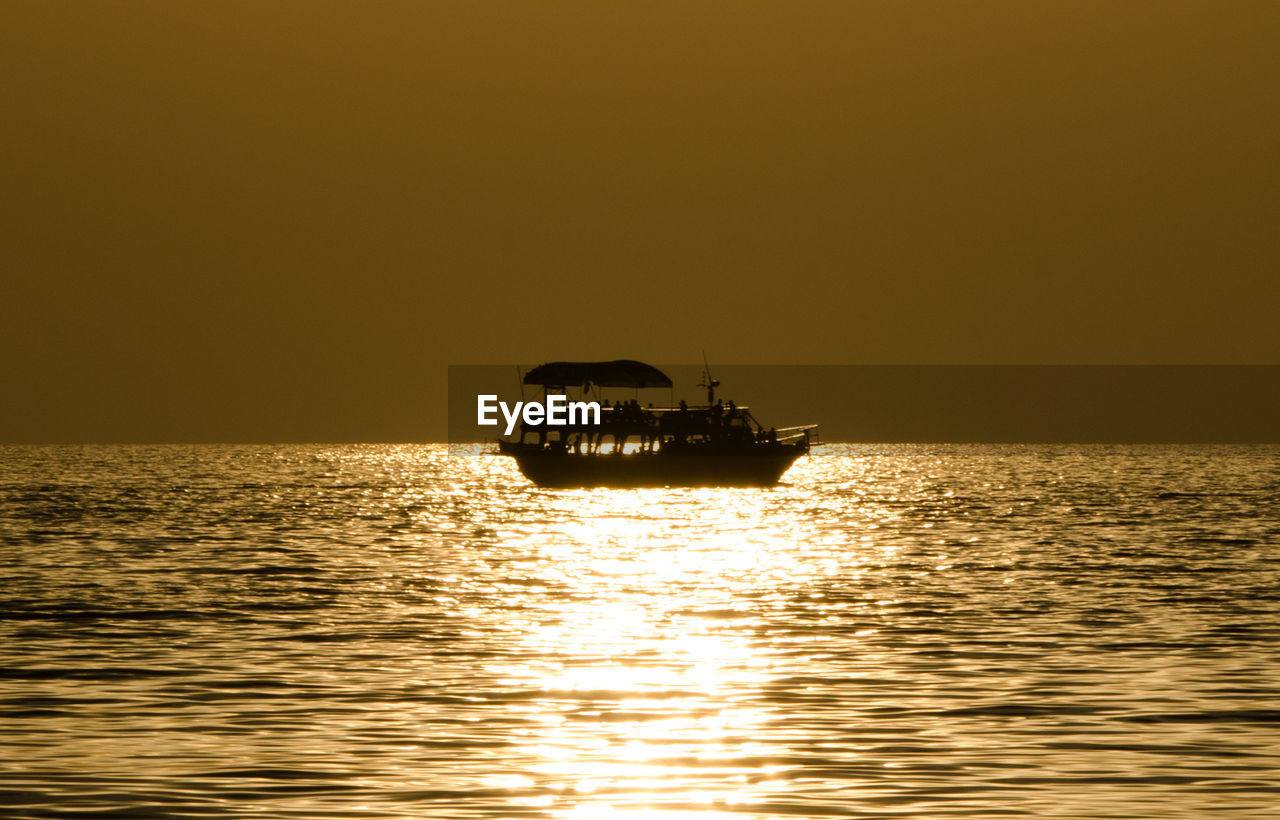 Lone boat in calm sea against clear sky