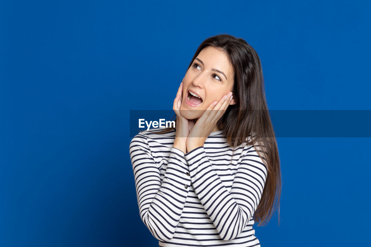 Smiling young woman against blue background