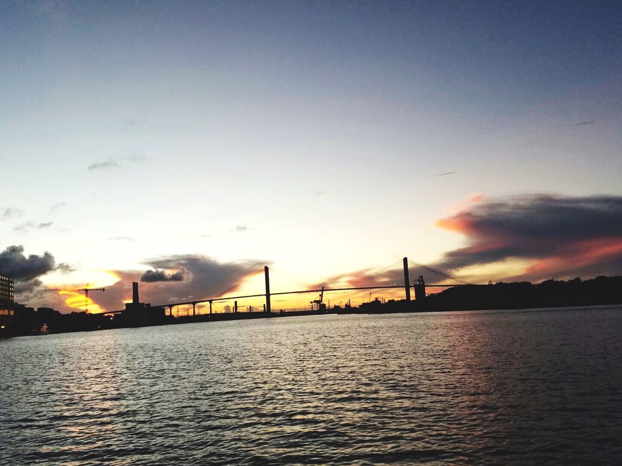 BRIDGE OVER RIVER IN CITY AGAINST SKY