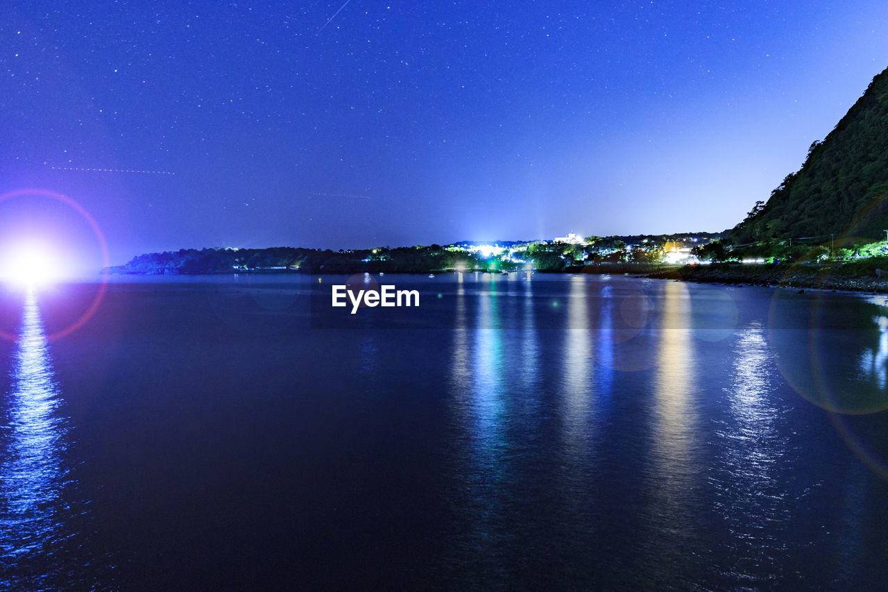 ILLUMINATED SEA AGAINST SKY AT NIGHT