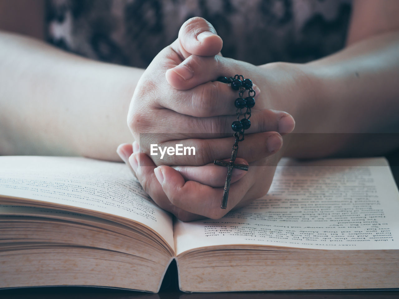 CLOSE-UP OF WOMAN HAND HOLDING BOOK ON TABLE