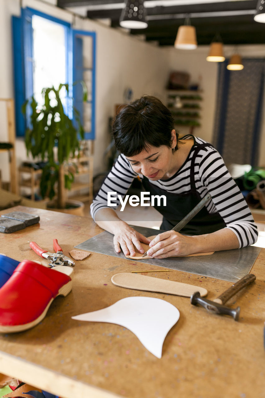 Shoemaker working on template in her workshop