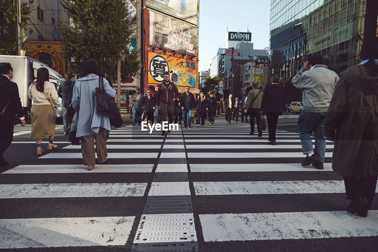 GROUP OF PEOPLE WALKING ON ROAD