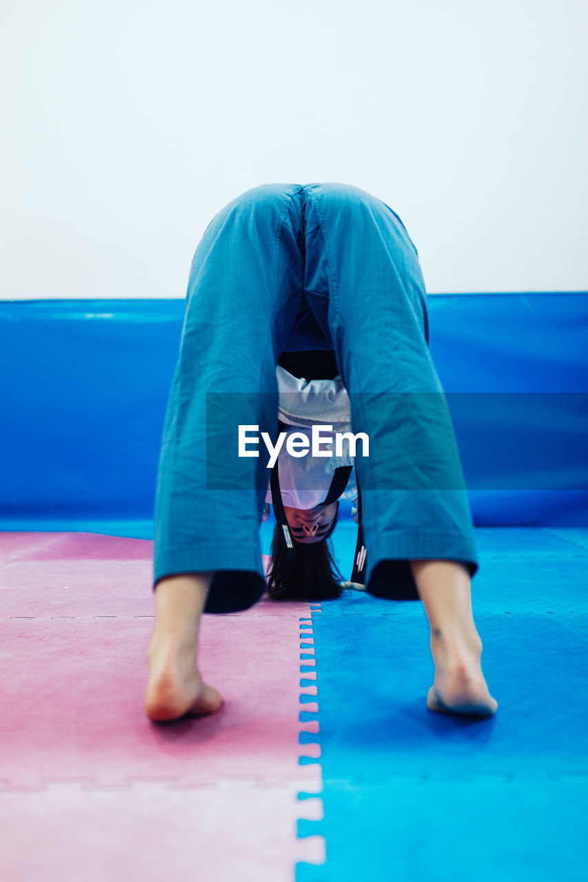 Rear view of young woman exercising at studio
