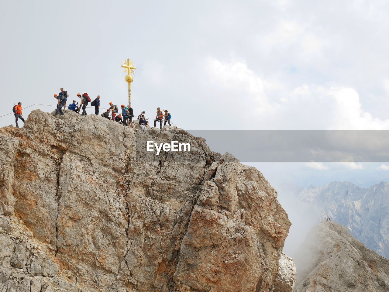 GROUP OF PEOPLE ON ROCK AGAINST SKY