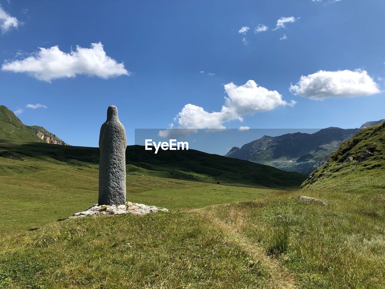 Cross on field against sky