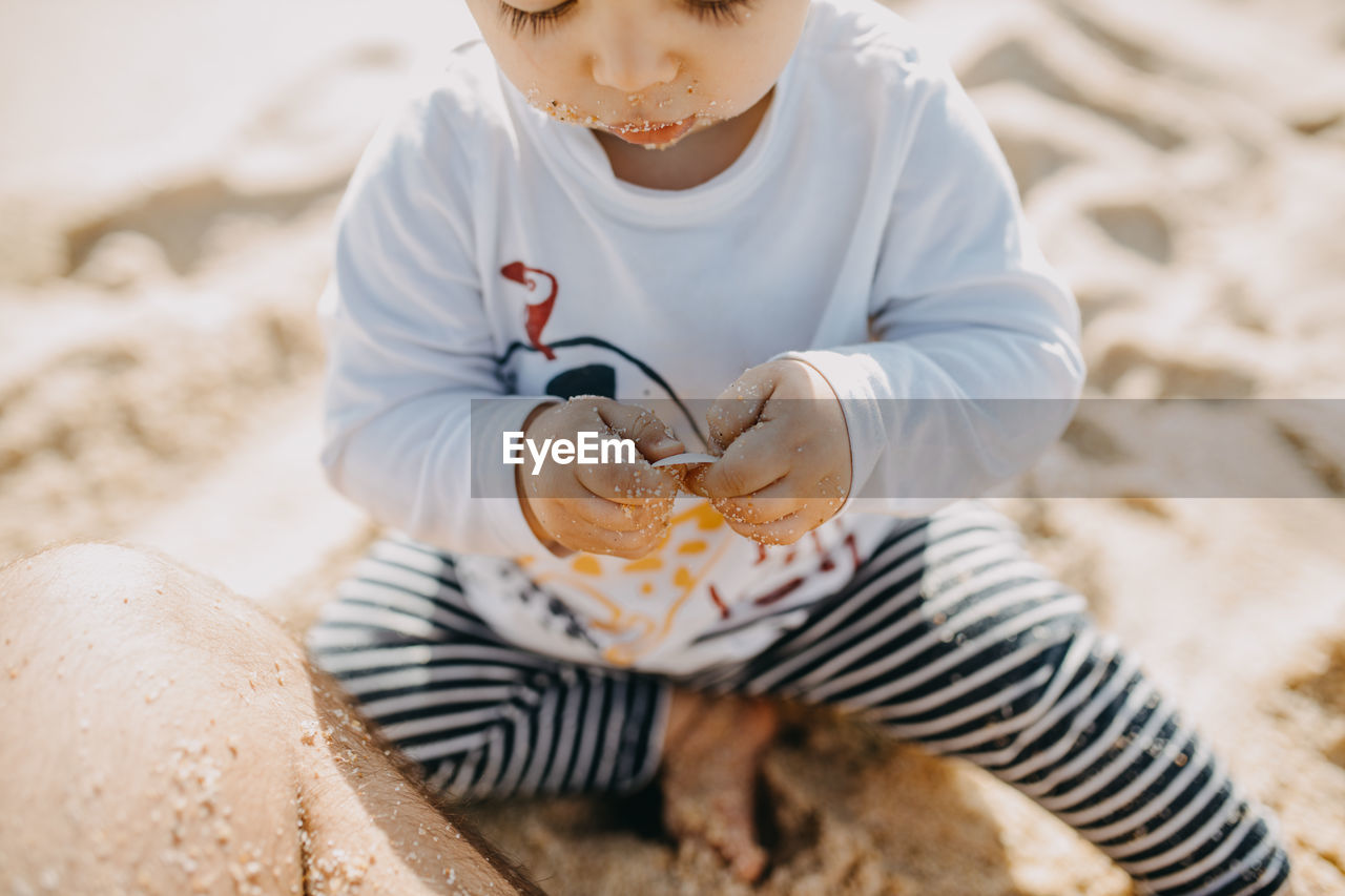 High angle view of boy sitting on beach