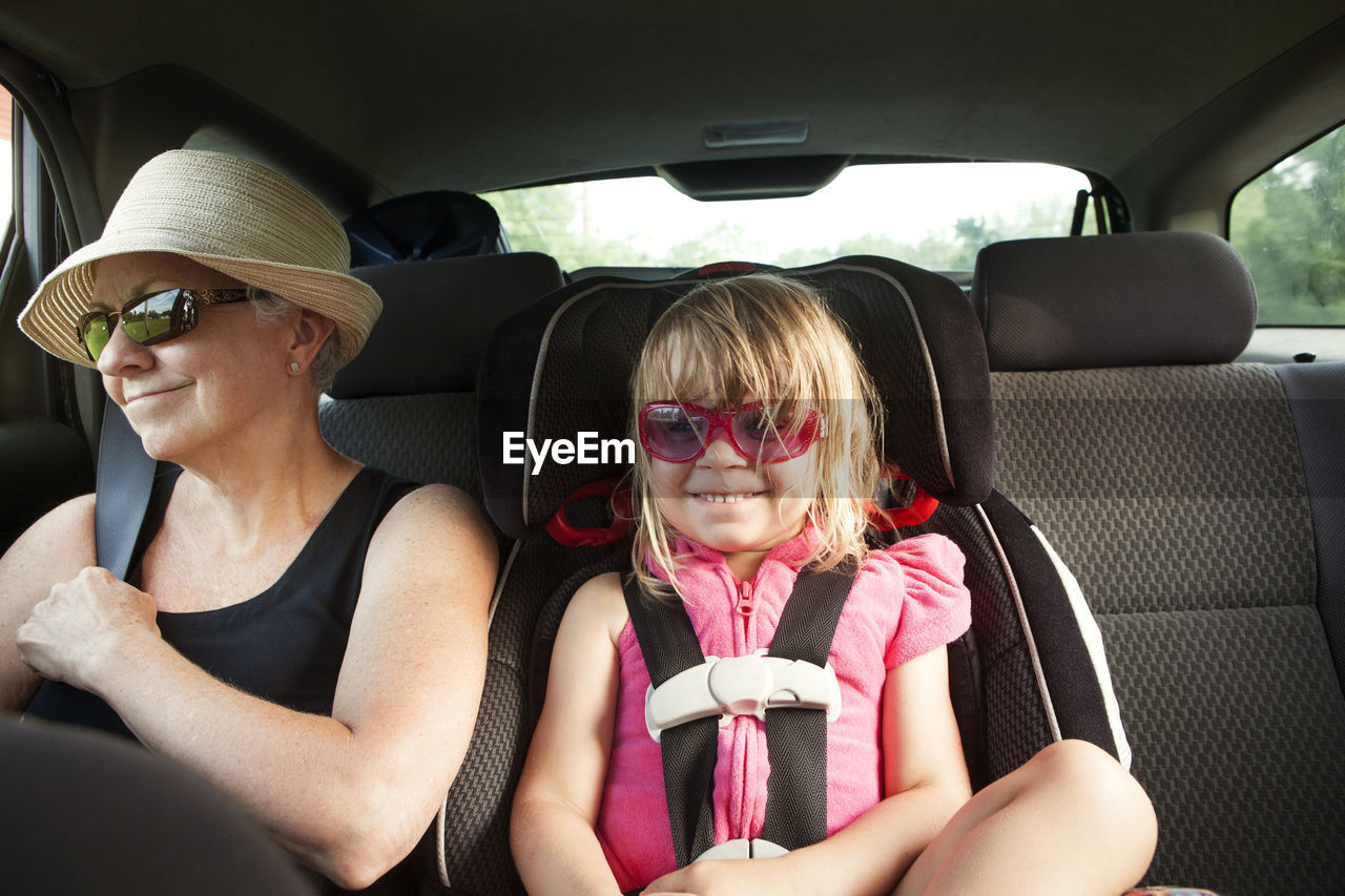 Grandmother and granddaughter sitting in car