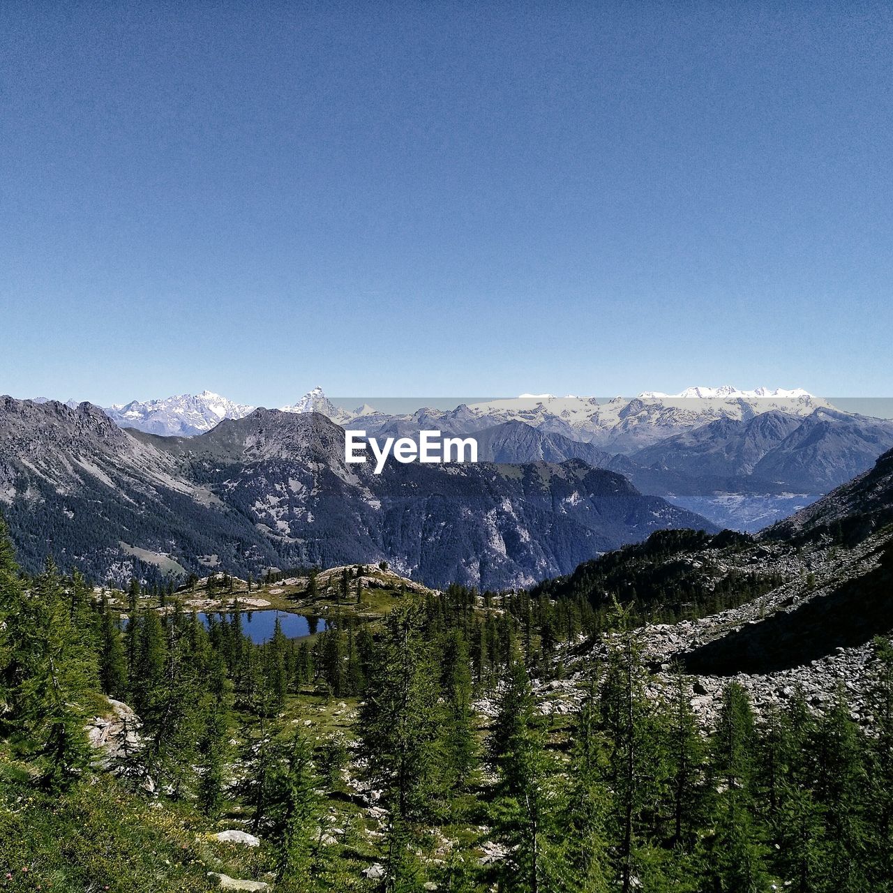 Scenic view of snow covered mountains against blue sky