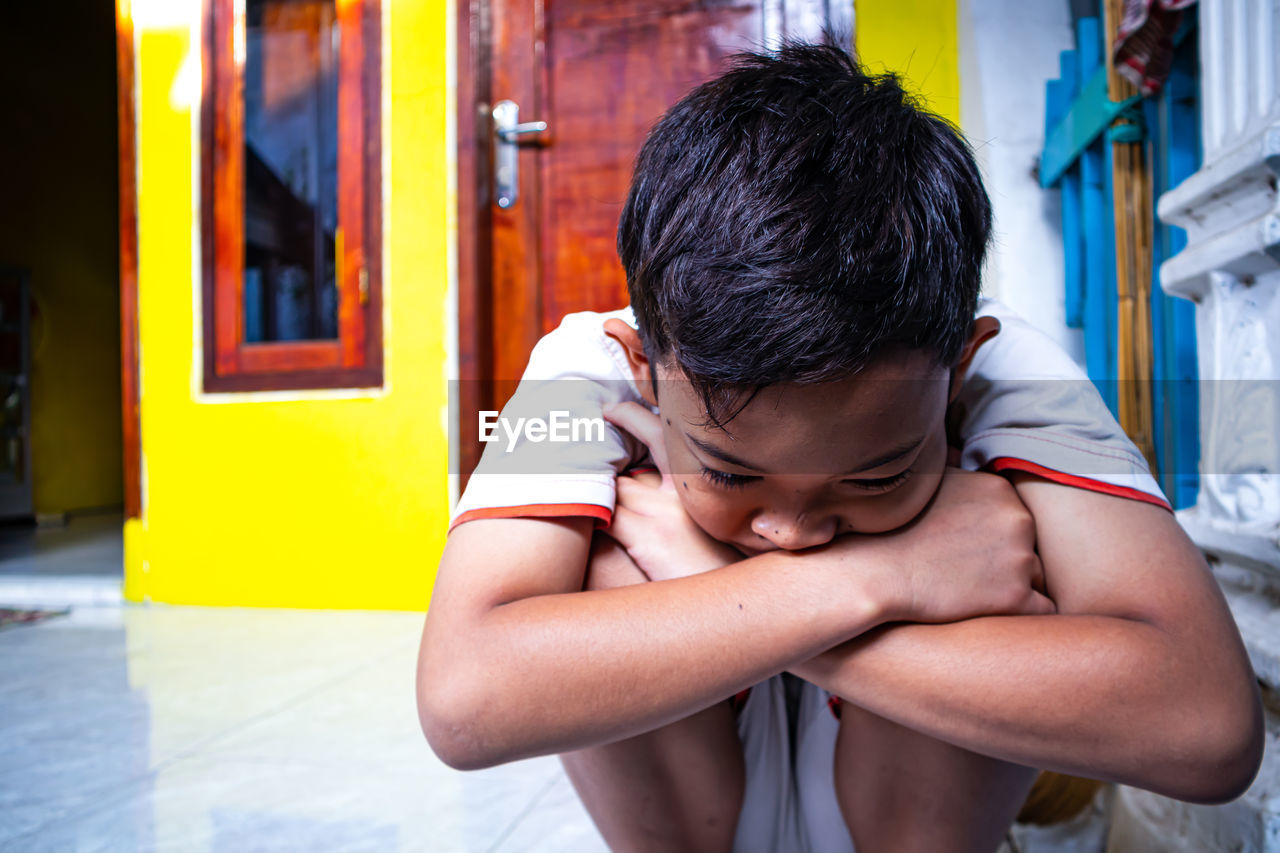Boy sitting on floor at home