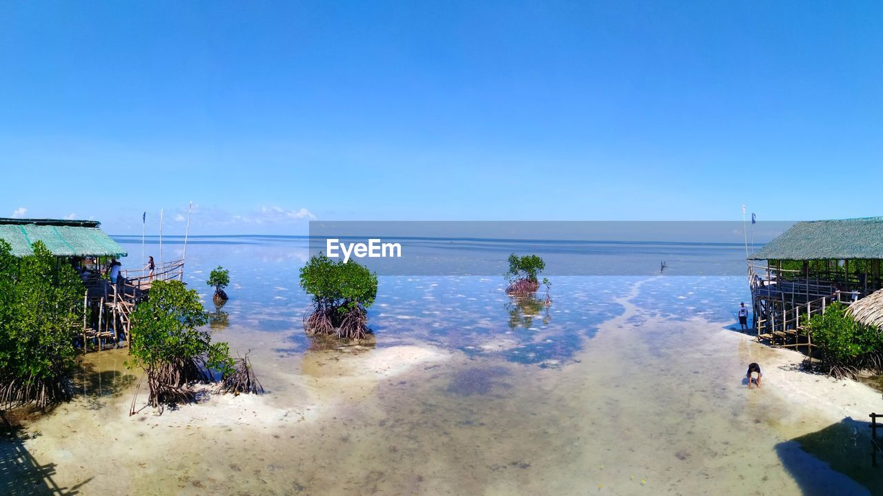 PANORAMIC VIEW OF BEACH AGAINST CLEAR BLUE SKY