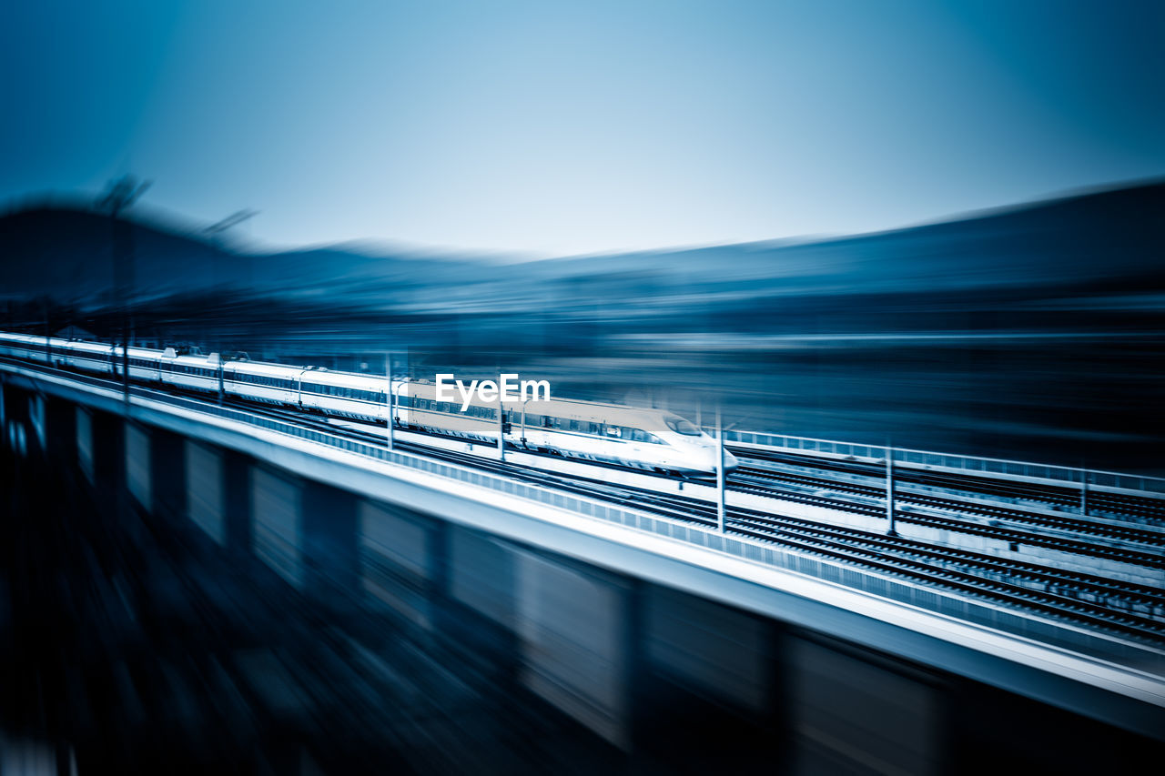 Blurred motion of train against clear blue sky