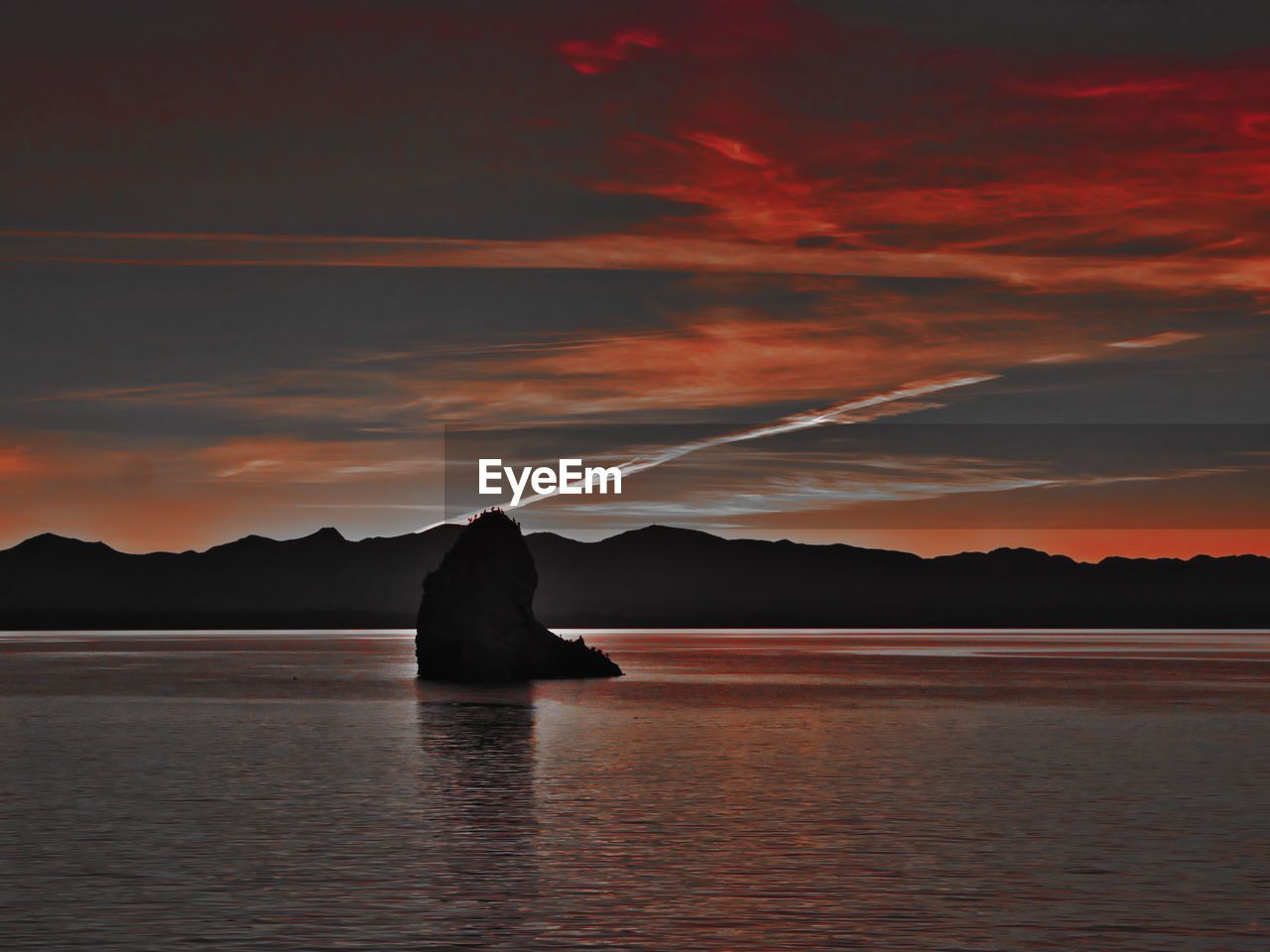 SILHOUETTE MAN ON LAKE AGAINST SKY DURING SUNSET