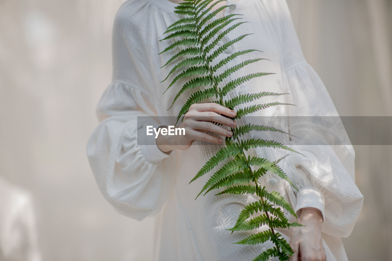 Midsection of woman holding plant