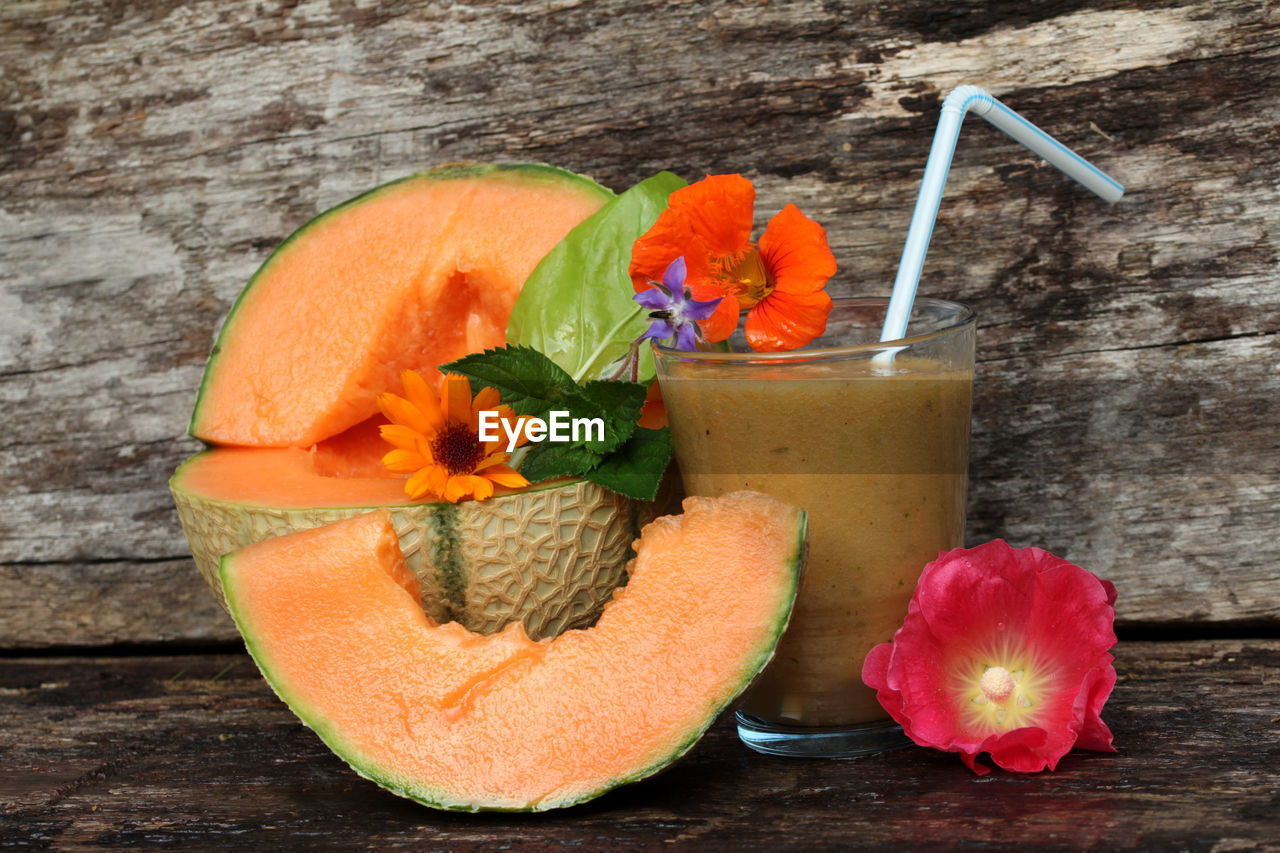 Close-up of cantaloupe with juice on wooden table
