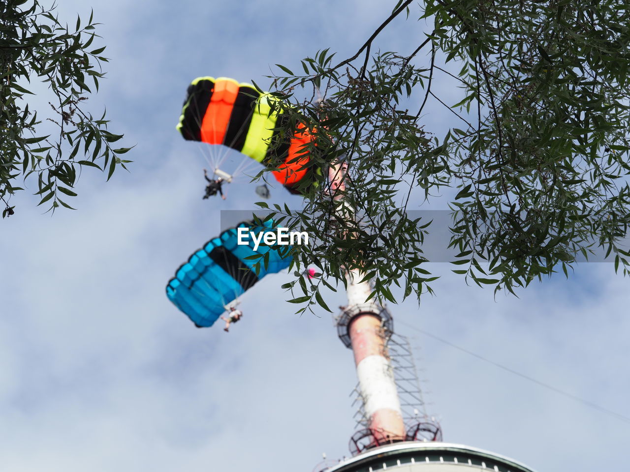 Low angle view of base jumpers against sky