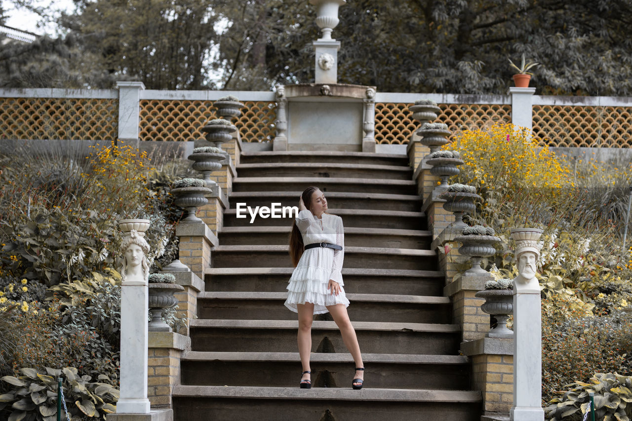 Full length of young woman standing on staircase