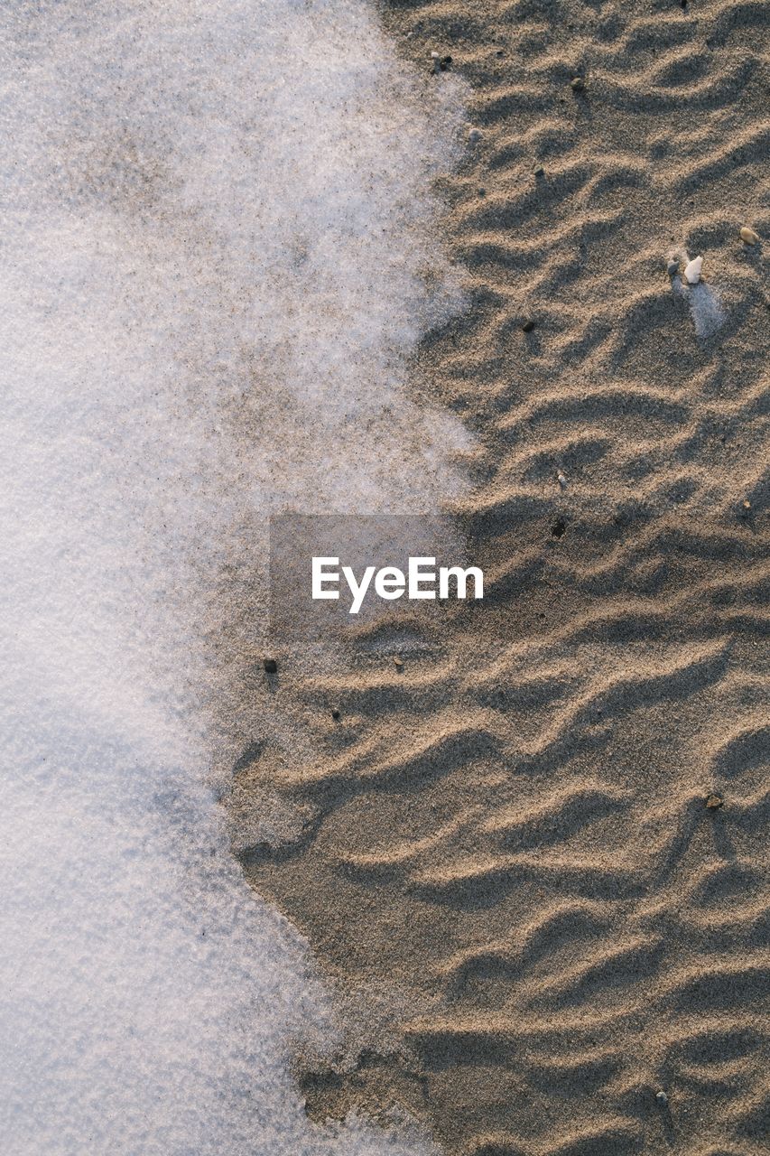 HIGH ANGLE VIEW OF FOOTPRINTS ON SAND AT SANDY BEACH