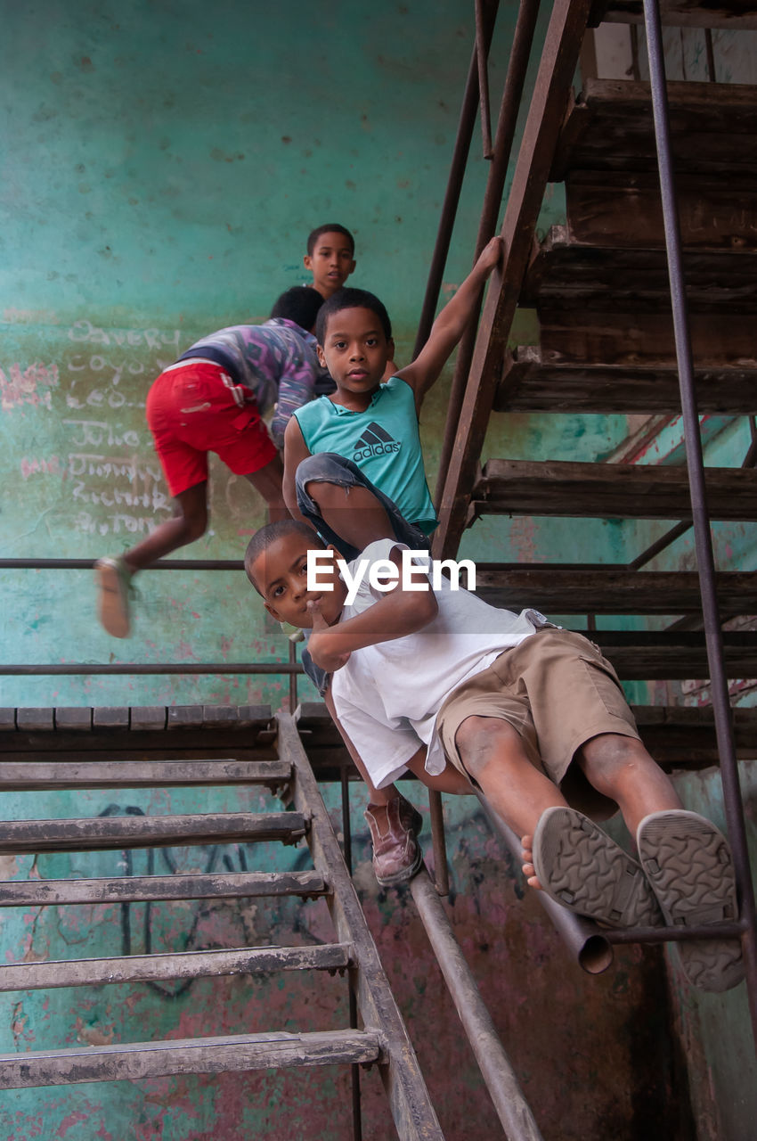 LOW ANGLE VIEW PORTRAIT OF BOYS ON STAIRCASE
