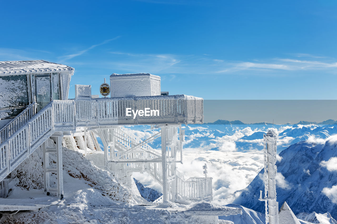 Snow covered observation point against blue sky