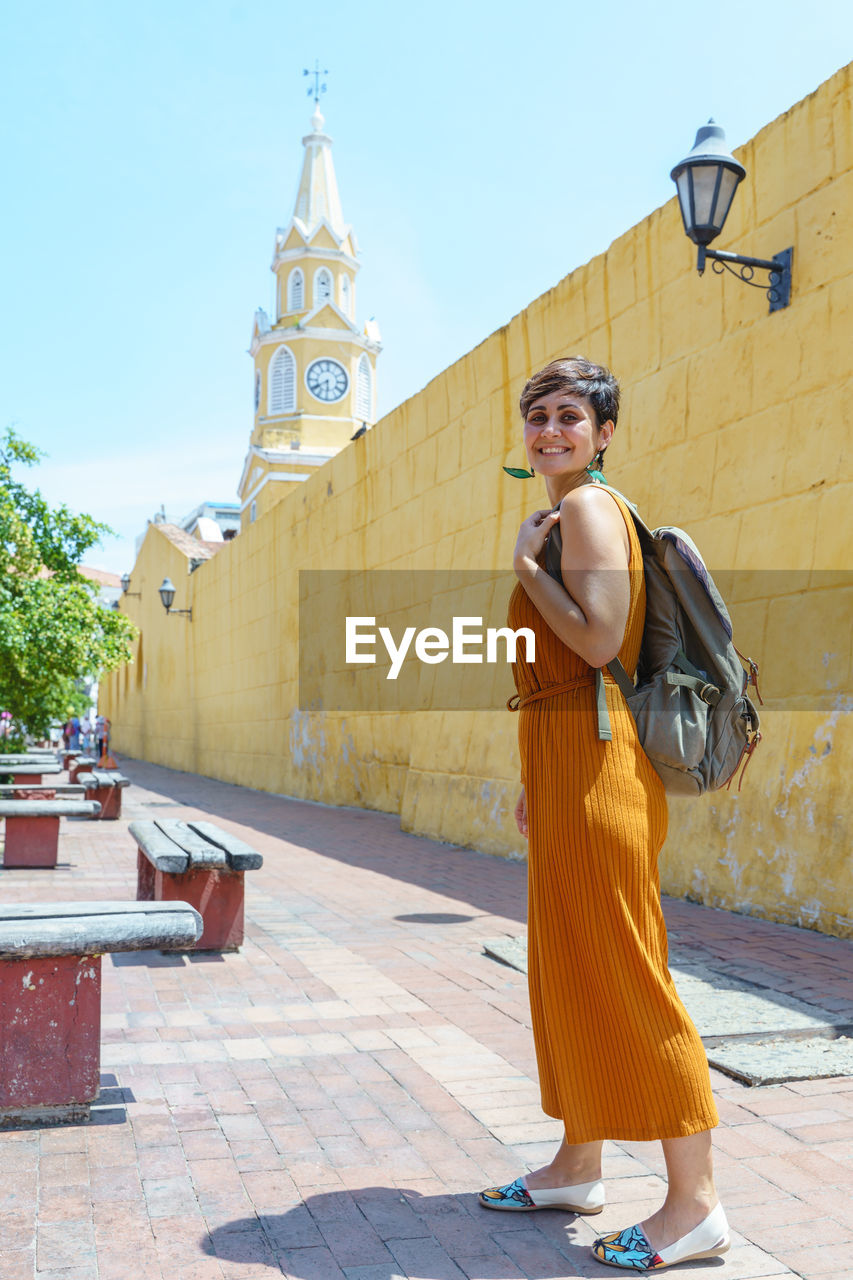 side view of young woman standing in front of church