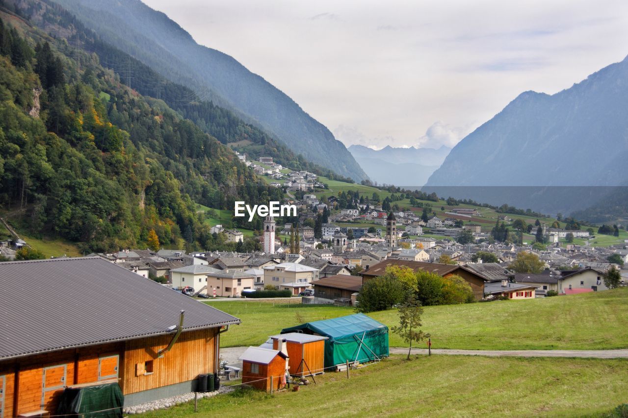 Houses by mountains against sky