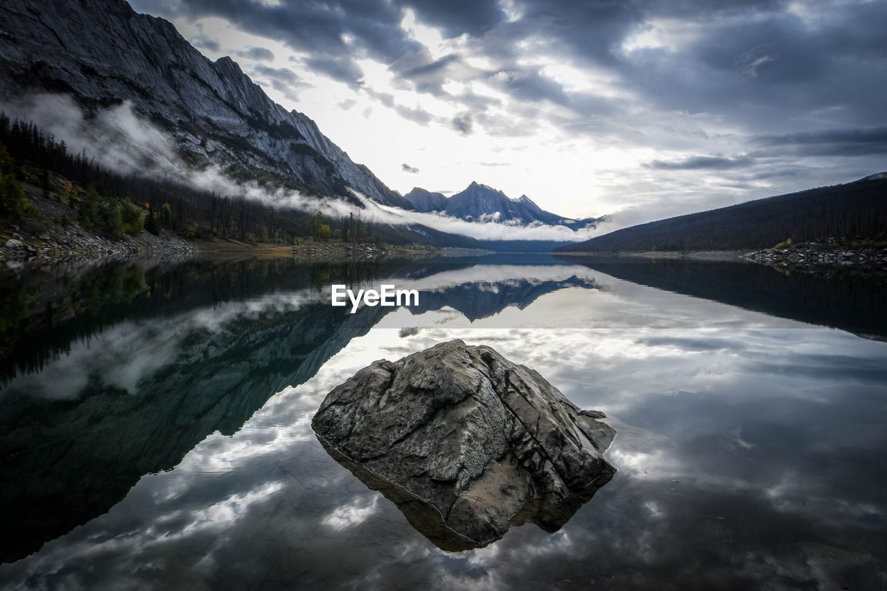 Scenic view of lake by mountains against sky