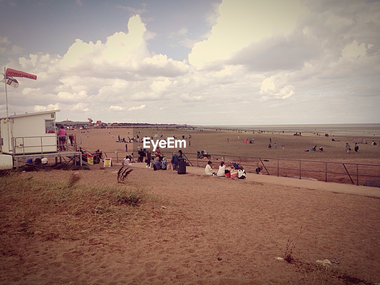 People at beach against sky