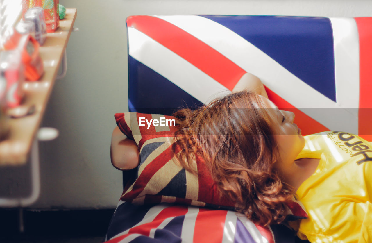 REAR VIEW OF WOMAN WITH UMBRELLA IN FLAGS