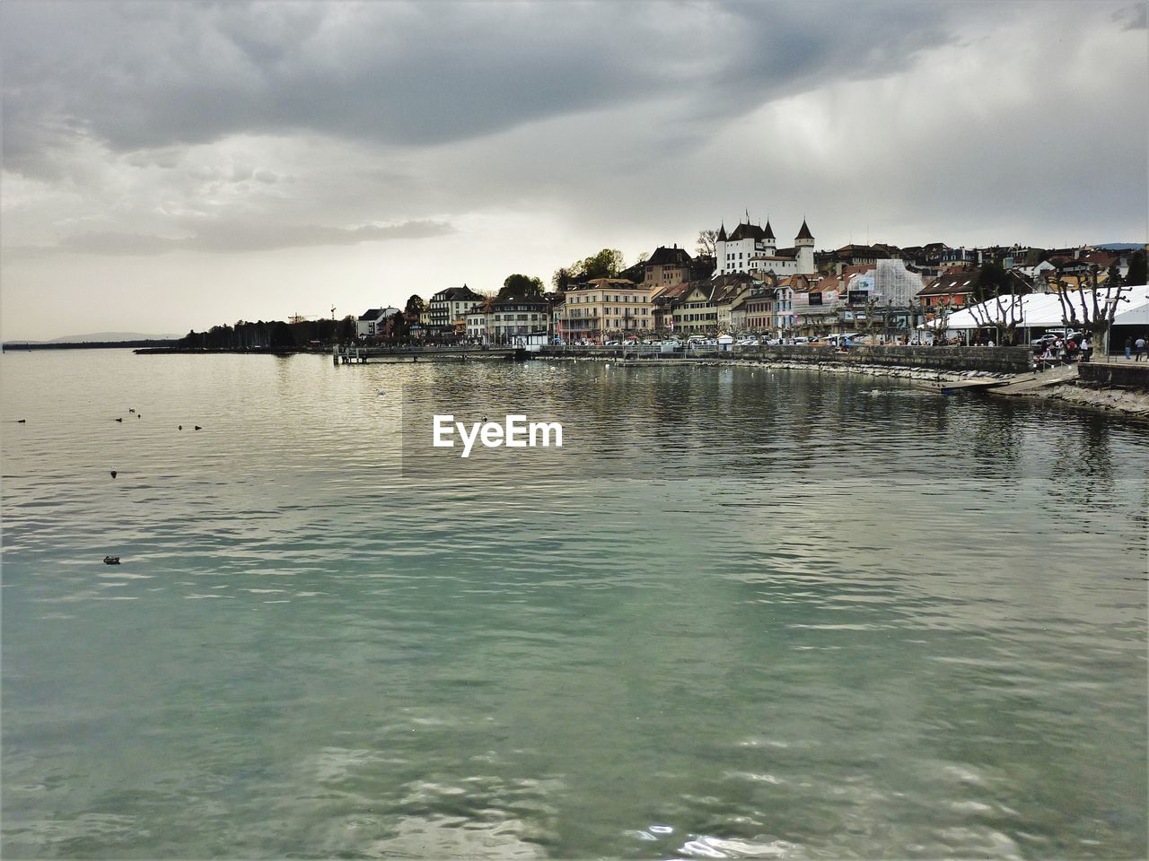 Buildings by sea against sky