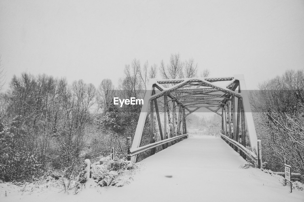 Snow covered bridge against clear sky