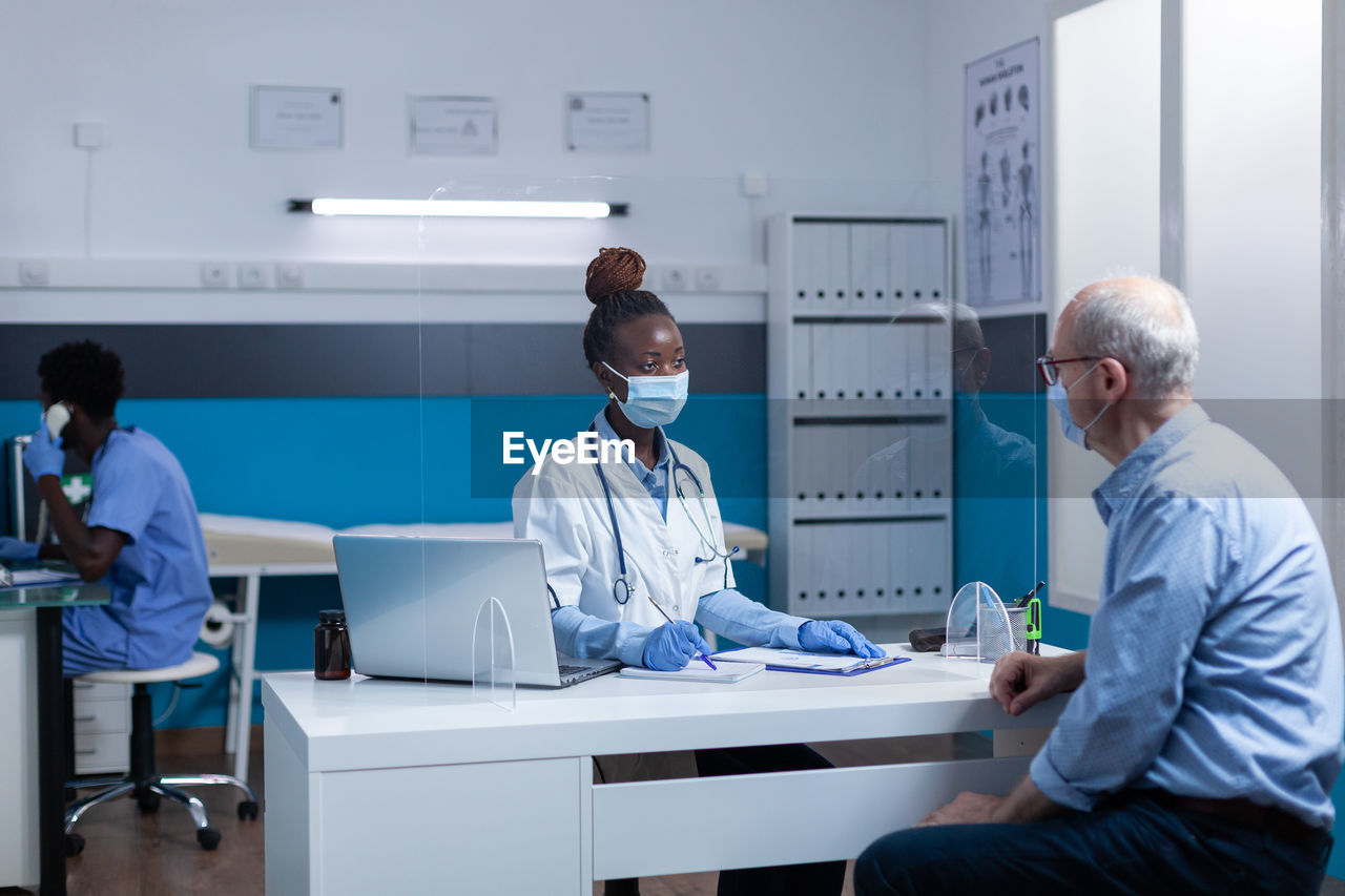 Doctor talking with male patient at clinic