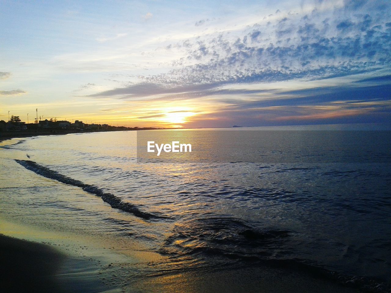 VIEW OF BEACH AGAINST CLOUDY SKY