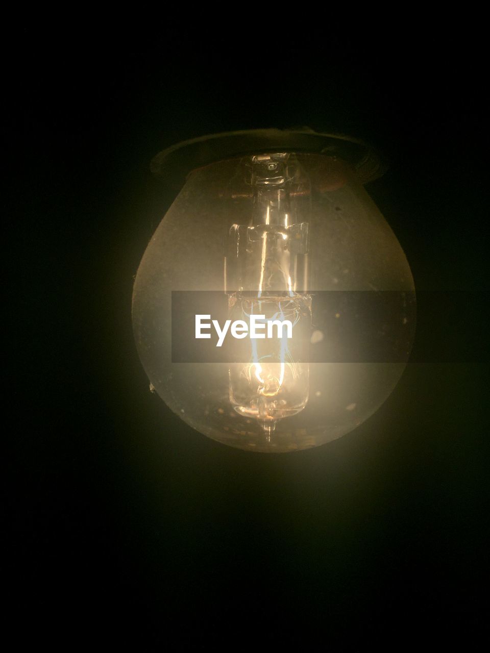 Close-up of illuminated light bulb in darkroom