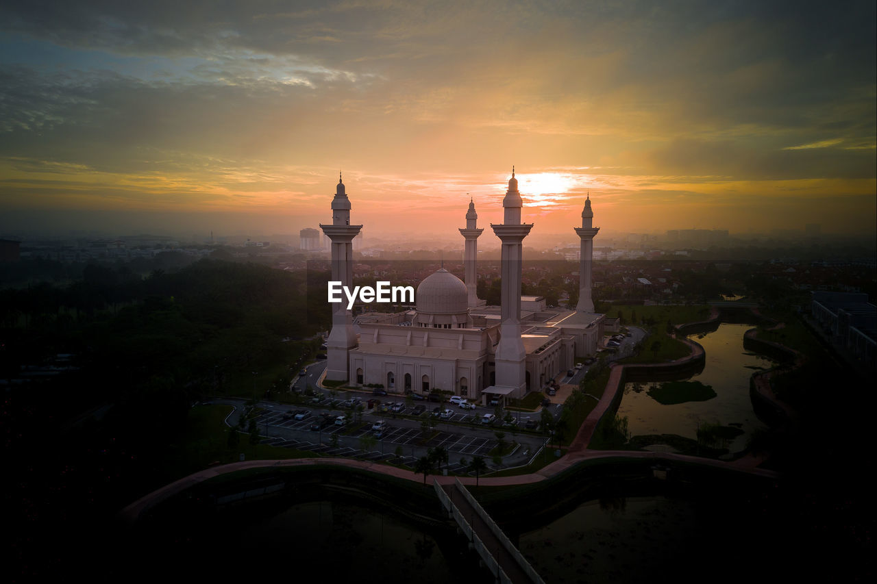 High angle view of mosque in city during sunrise