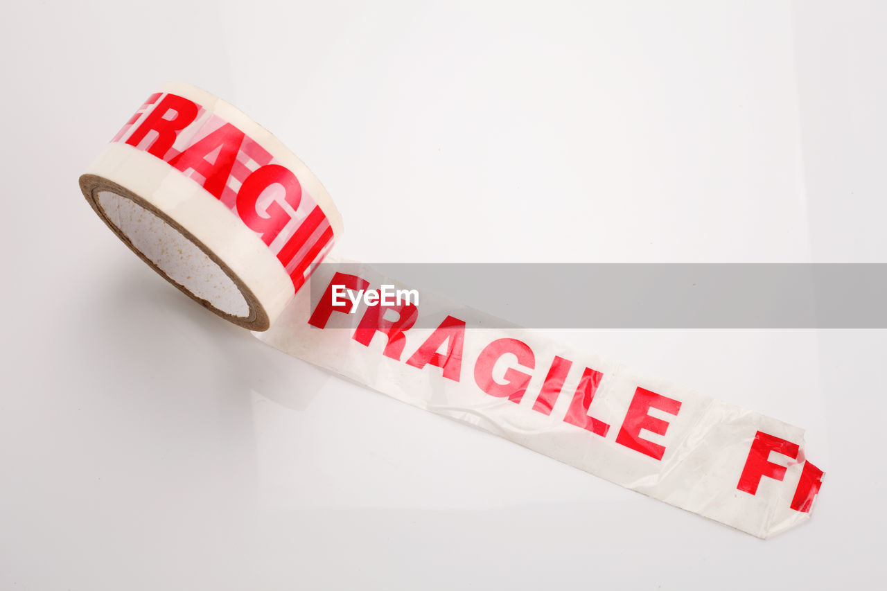 High angle view of text on adhesive tape over white background