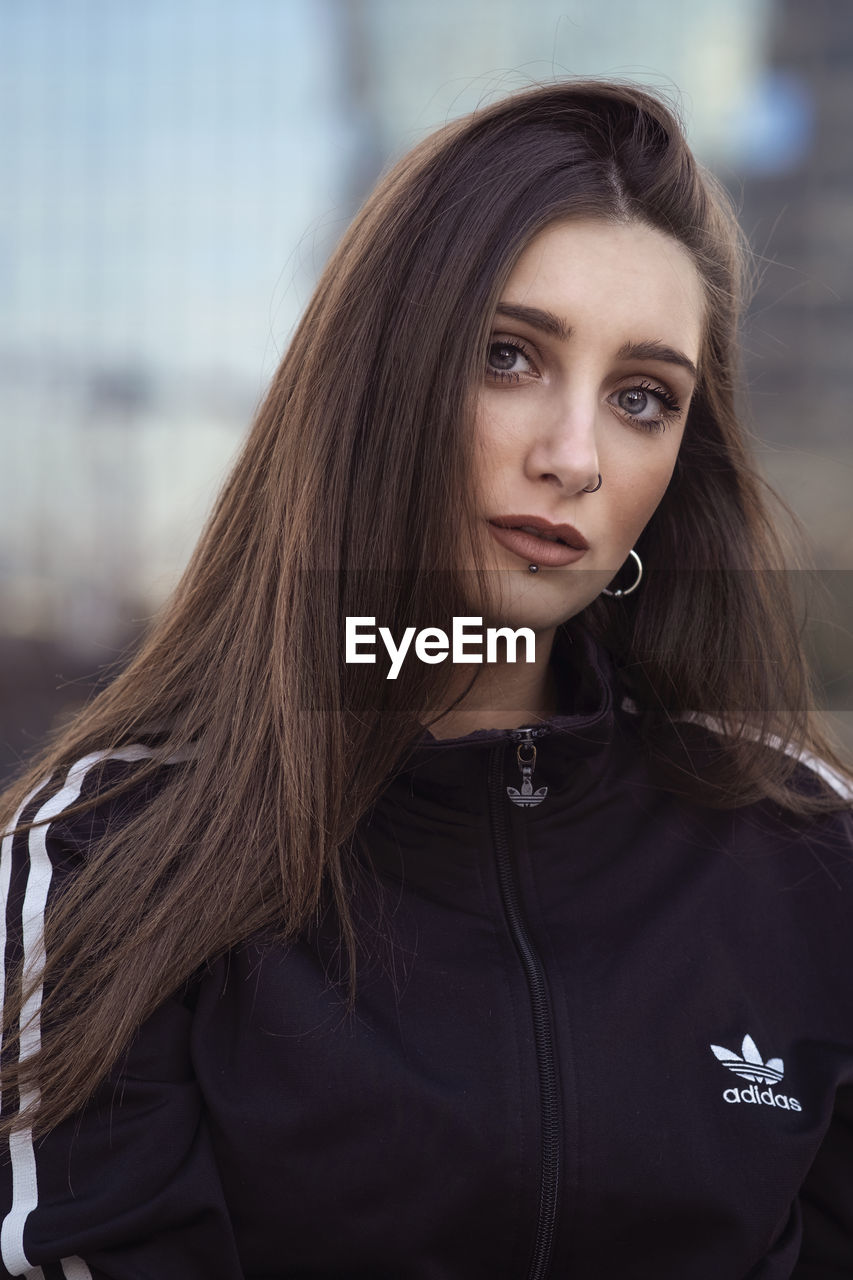 PORTRAIT OF YOUNG WOMAN WITH HAIR IN BACKGROUND